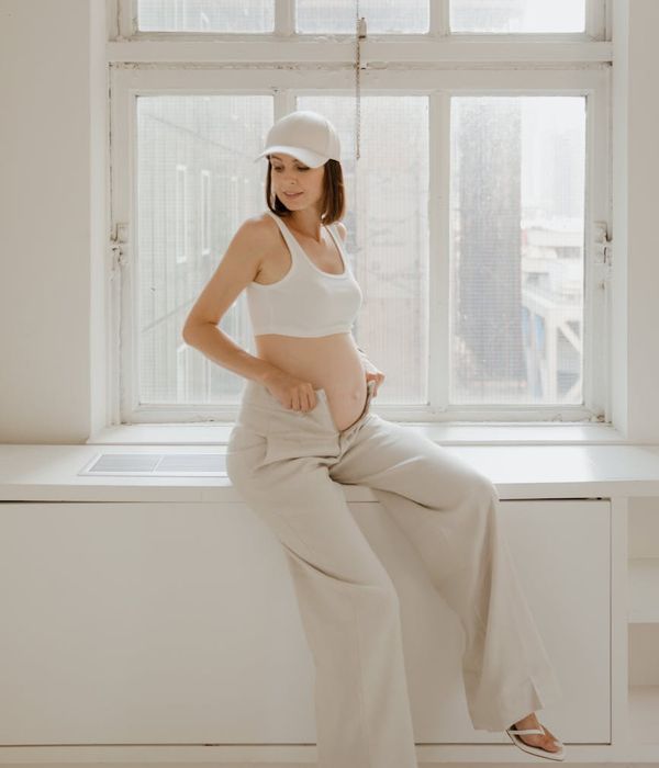 Serene pregnant woman in a gentle yoga pose.